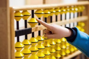 Child using abacus beads to develop number sense and mental calculation skills