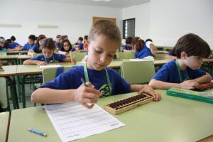 Students practicing math problems using abacus for Olympiad preparation