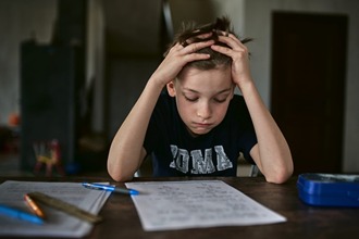 Child feeling stressed while solving math homework at home