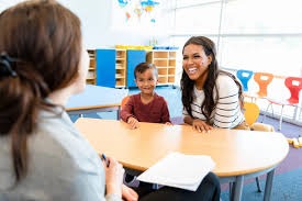 Teacher discussing student progress with parent in a classroom setting