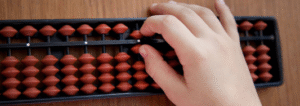 Child practicing calculations on an abacus to improve focus and mental math skills.