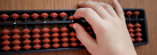 Child practicing calculations on an abacus to improve focus and mental math skills.