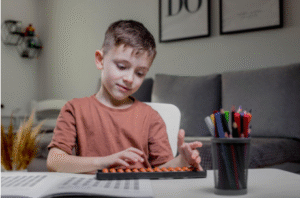 Young boy learning abacus at home to improve mathematical and cognitive skills.