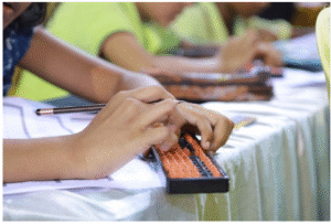 Children practicing calculations on an abacus during a mental maths training session.