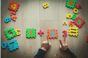 Child learning addition using colorful number blocks and educational math toys.